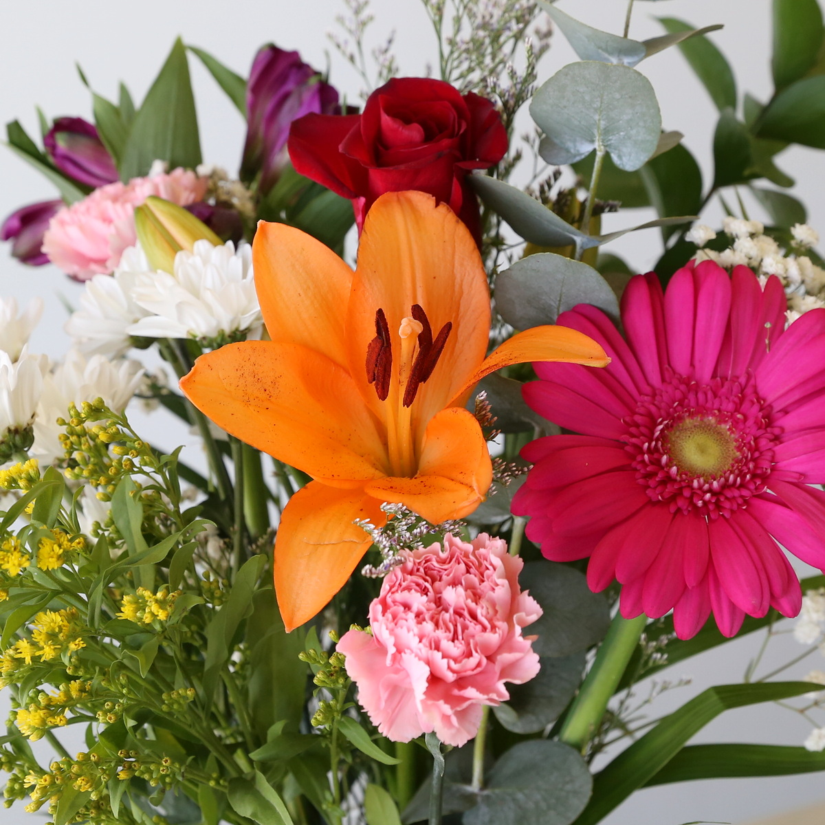 close up of bulk flower bundle with lily gerbera rose carnation eucalyptus and mixed filler flowers